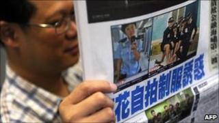 A man reads a local newspaper in Hong Kong on July 14, 2011 featuring front page photos of police woman posing in controversial images.