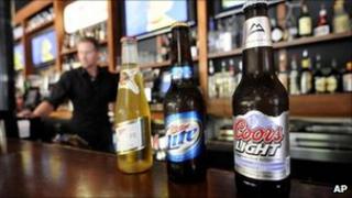 Three bottles of MillerCoors beer sitting on a bar