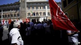 Pensioners stand outside the Italian parliament after a demonstration on 15 July 2011 in Rome.