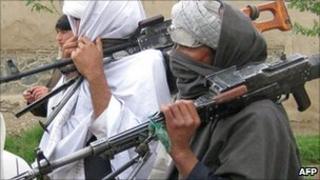 Taliban fighters peacefully surrender their arms during a meeting with Afghan government officials as part of the government's peace and reintegration process, 11 April 2011