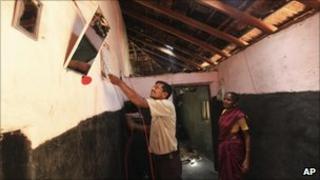 In this May 24, 2011 photograph, Parvin Yeyyada works with electric wiring as Boommi Gowda looks on during the installation of solar power in her house in Nada