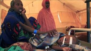 A Somali woman comforts her son as he rests in a hospital