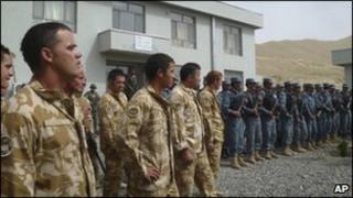 Soldiers from New Zealand (L) part of the Nato- led International Security Assistance Force (Isaf) stand on a line with Afghan policemen during handover control for security in Bamiyan