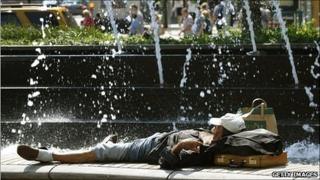 A man laying in front of a fountain