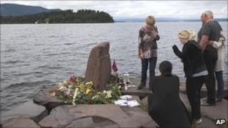 Relatives mourn a lost loved one opposite Utoeya island