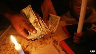 A Zimbabwean counts US bank notes in Harare (6 October 2010)
