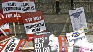 Discarded placards are left in the street as a child rests on a wall during a nationwide day of strikes in central London, Thursday, June 30, 2011.