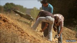 Rebel fighters set up a weapon on a makeshift launcher targeting positions of pro-Gaddafi soldiers on the frontline near the town of Zlitan July 29, 2011.