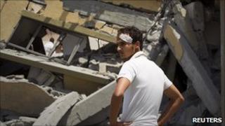 A man looks at a house that Libyan officials say was bombed by Nato forces, killing two children and their mother near Zlitan