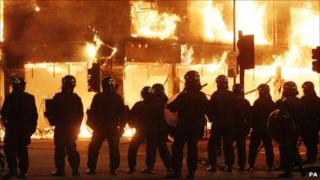 Riot police infront of burning building in Tottenham, 2011