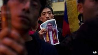 A Tibetan exile holds a portrait of Tsewang Norbu, during a candle light vigil in Dharmsala, India, Monday, Aug. 15, 2011