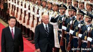 Chinese Vice-President Xi Jinping accompanies US Vice-President Joe Biden (R) to view an honour guard during a welcoming ceremony in Beijing