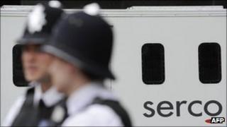 Two police officers with a Serco prison van