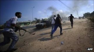 Libyan rebels run for cover during fighting against regime forces near Jaddayim west of Tripoli, on August 21, 2011