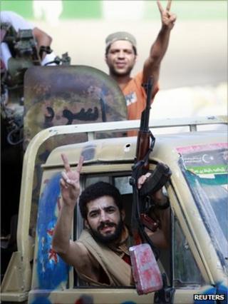 Libyan rebel fighters celebrate as they drive through Tripoli's Qarqarsh district