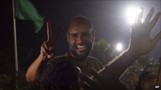 Saif al-Islam gestures to troops loyal to his father in Tripoli in the early hours of Tuesday 23 August