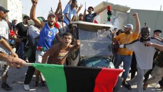 Libyan rebel fighters celebrate entering Colonel Gaddafi's compound in Tripoli.