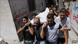 Palestinians carry the body of a dead tunnel worker in a Rafah funeral procession.