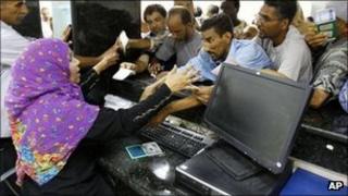 People rush to get cash from their accounts after the Libyan banks reopen