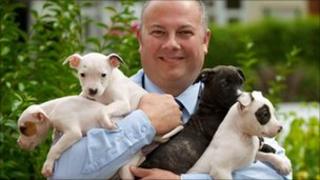 Det Con Lee Dawson with four of the recovered puppies. Photo: West Midlands Police