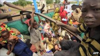 Displaced people ride a lorry to return to their homes in Sudan's Blue Nile region, 6 September 2011