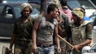 Egyptian soldiers detain a suspected protester near the Israeli embassy in Cairo, 10 September