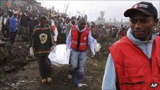 Kenya Red Cross personnel carry the lifeless body of a victim of a gasoline pipeline explosion in a slum area of Nairobi, Kenya, Tuesday, Sept. 13