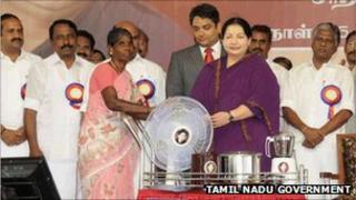 J Jayalalitha giving away freebies that she promised during her campaign