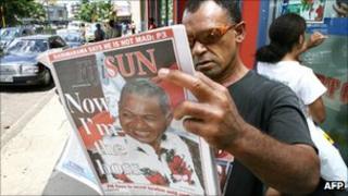 Мужчина читает газету после переворота 2006 года на Фиджи