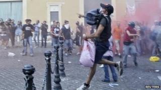 Протестующие против жесткой экономии бросают ракеты во время акции протеста перед зданием итальянского парламента в центре Рима
