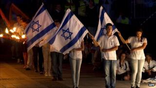 Israelis hold their national flag during a one-minute silence on May 8, 2011 to mark Remembrance Day