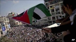 A girl waves a Palestinian flag from a balcony in Ramallah, the West Bank, 21 September