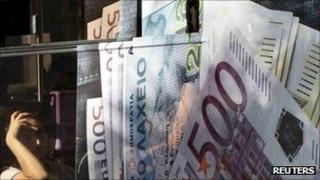 Мужчина смотрит на изображение банкноты евро в Афинах. Фото: сентябрь 2011 г.