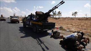 Anti-Gaddafi fighters pray near the front line outside Sirte. 28 Sept 2011