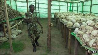 A Rwandan soldier looks at hundreds of human skulls and remains of genocide victims at the genocide memorial in Bisesero, Rwanda, in 1999