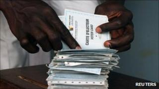 A man searches for his voting card at a polling unit during the presidential election in Cameroon"s capital Yaounde October 9, 2011.