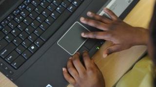 A black pupil's hands on a laptop