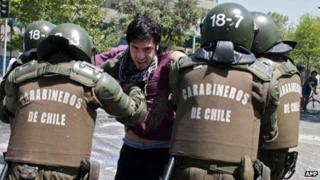 Chilean police arrest a demonstrator during protests on 19 October