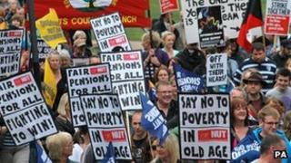 Protesters hold placards in Nottingham city centre during a one day national strike against pension changes and funding cuts to the public sector, June 2011.
