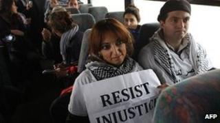 Two Palestinian activists sit inside as Israeli bus as it rides between a bus stop outside the West Bank Jewish settlement of Migron, near Ramallah, and a checkpoint leading to Jerusalem