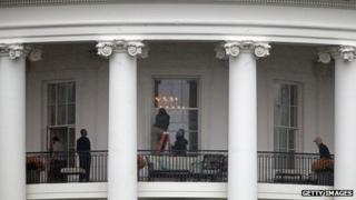 Law enforcement officials examine a White House window for damage