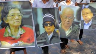 Cambodian students hold portrait photos of former Khmer Rouge leaders at an outreach programme in Phnom Penh on 18 November 2011