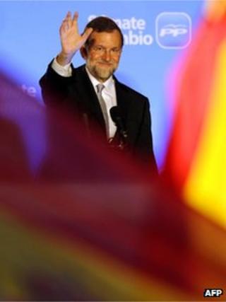 Leader of the Spanish Popular Party (PP) Mariano Rajoy (C) waves to supporters from the balcony of the PP headquarters in Madrid on 20 November 2011
