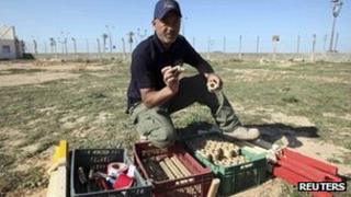 An employee of the Aman Society for demining and removal of war ordnance shows landmines that were planted by Gaddafi forces near Mitiga airport in Tripoli - 16 November 2011