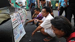Тайские мужчины читают газеты в центре Бангкока