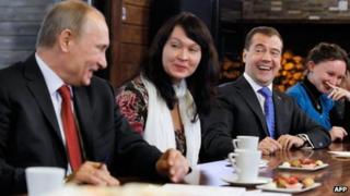 Vladimir Putin (left) and Dmitry Medvedev meet women's representatives near Moscow, 25 November