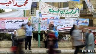 People walk past election campaign banners in Cairo (27 November 2011)