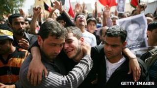Family members mourn during a funeral for a protester on 18 February 2011 in Sitra, Bahrain