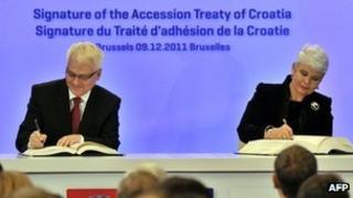 Croatian President Ivo Josipovic (left) and Prime Minister Jadranka Kosor sign their country's accession treaty in Brussels, 9 December