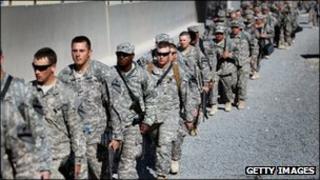 Army soldiers from the 1st Cavalry Division walk to a waiting bus as they leave customs for a ride to the airport to fly back to Fort Hood from Kuwait after exiting from Iraq